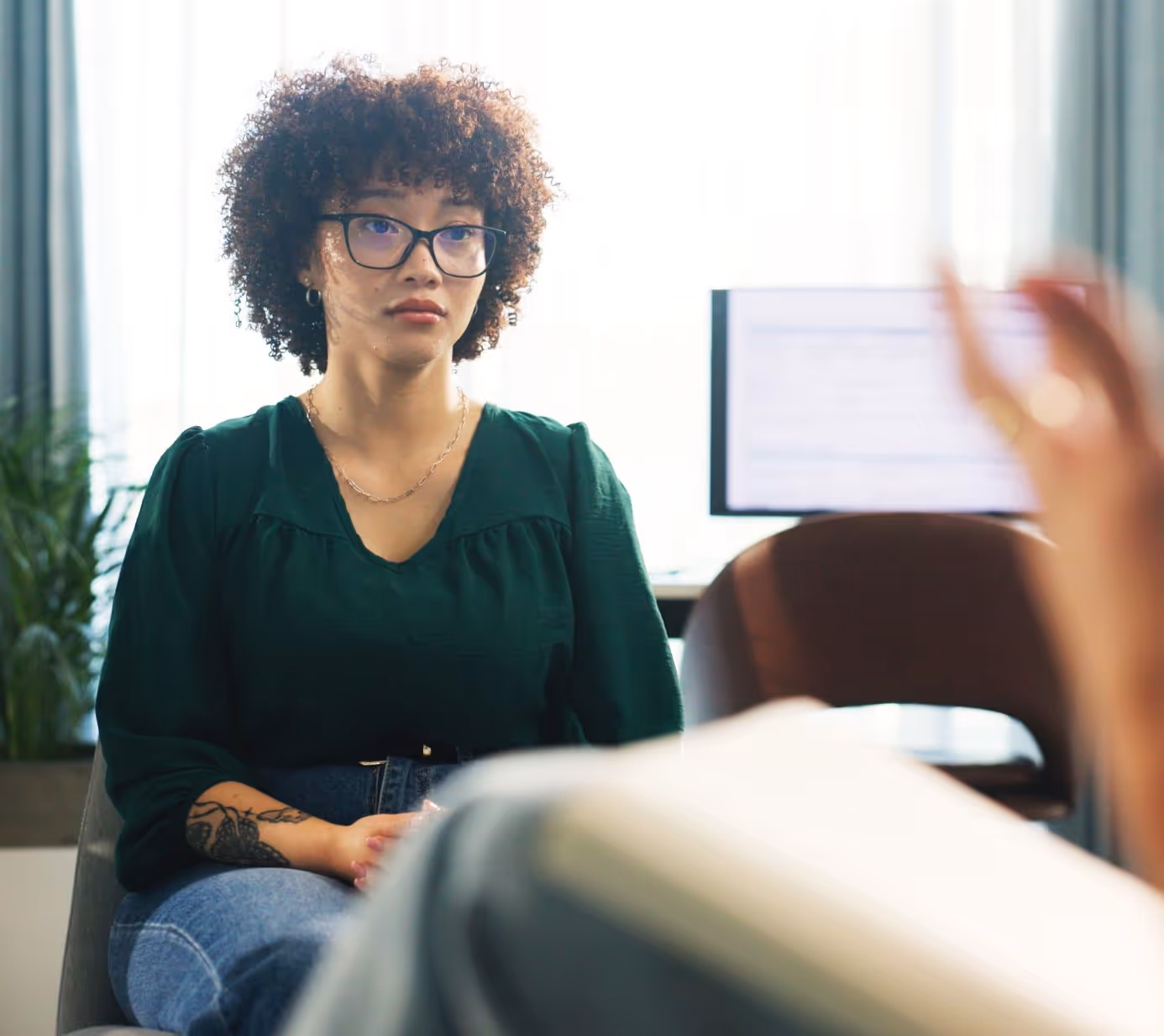 Young woman with curly hair seeks help for gastrointestinal disorder.