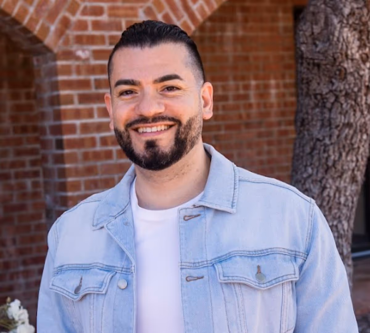 Dr. Trace Huang smiling at the camera while outdoors in casual clothes.