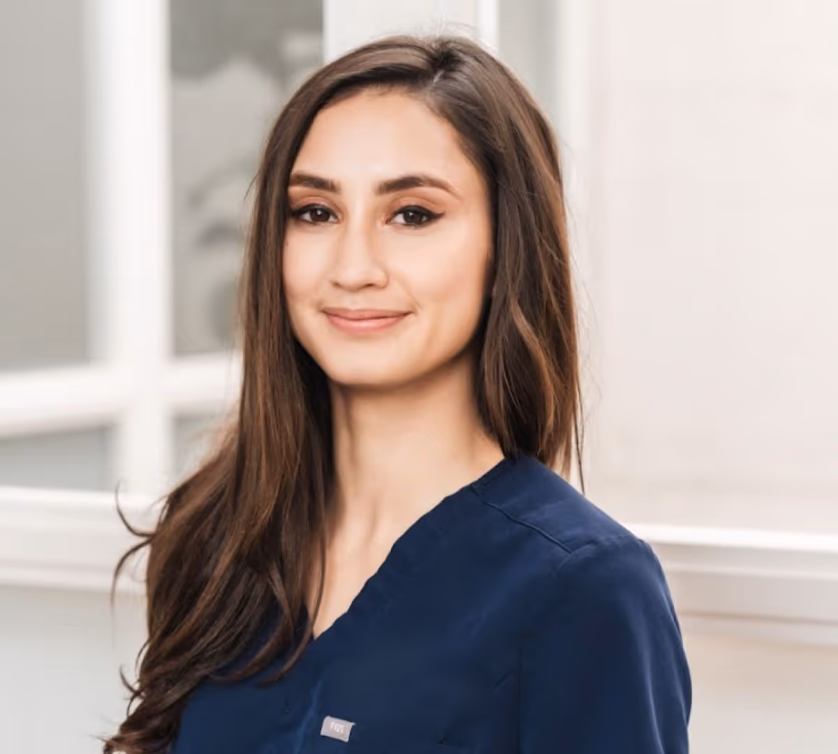 Headshot of Dr. Courtney Maloney in a blue scrub top smiling at the camera.