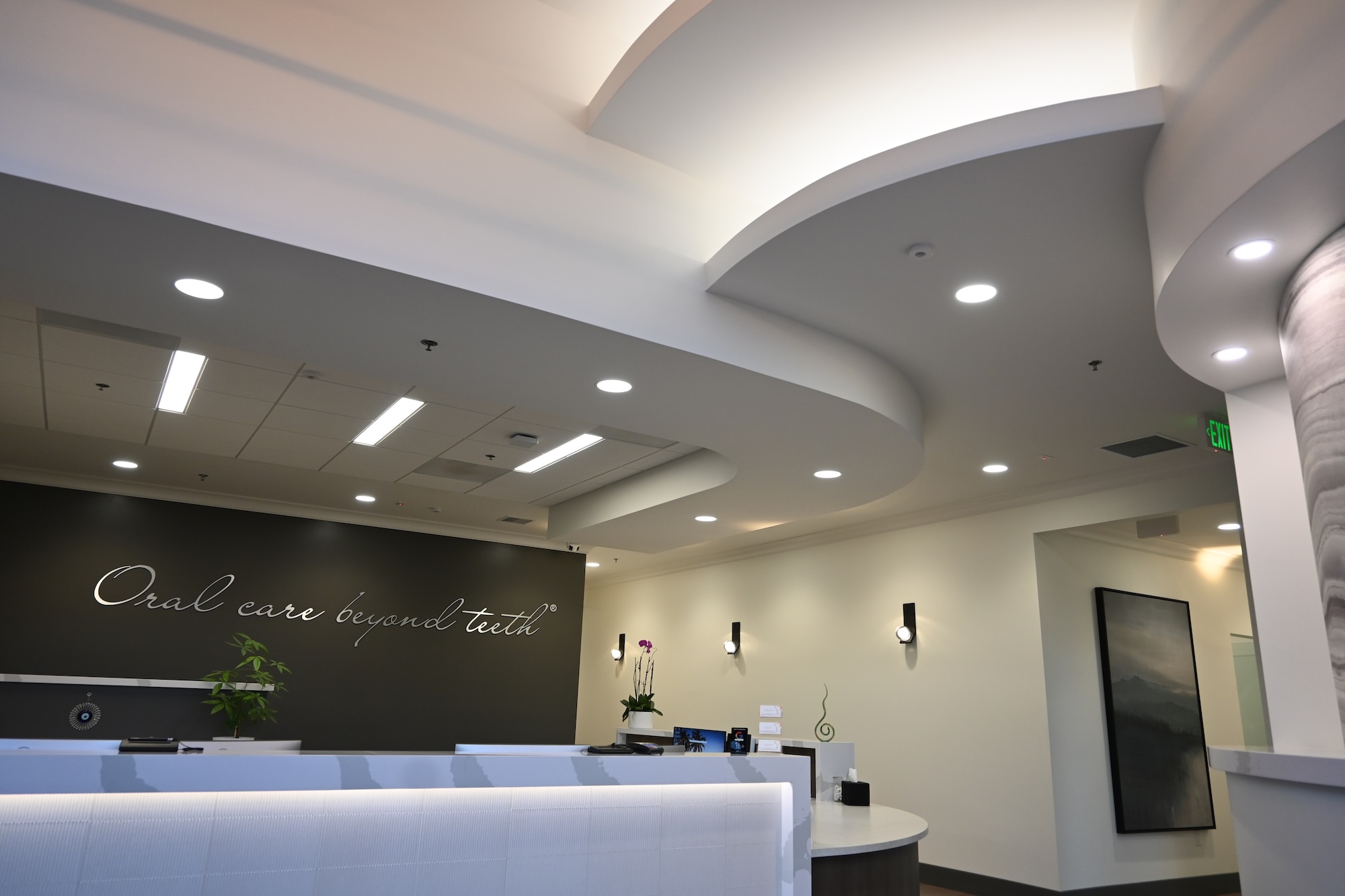 Modern lobby design with curved ceilings and elegant lighting in a dental office located in Roseville, CA.