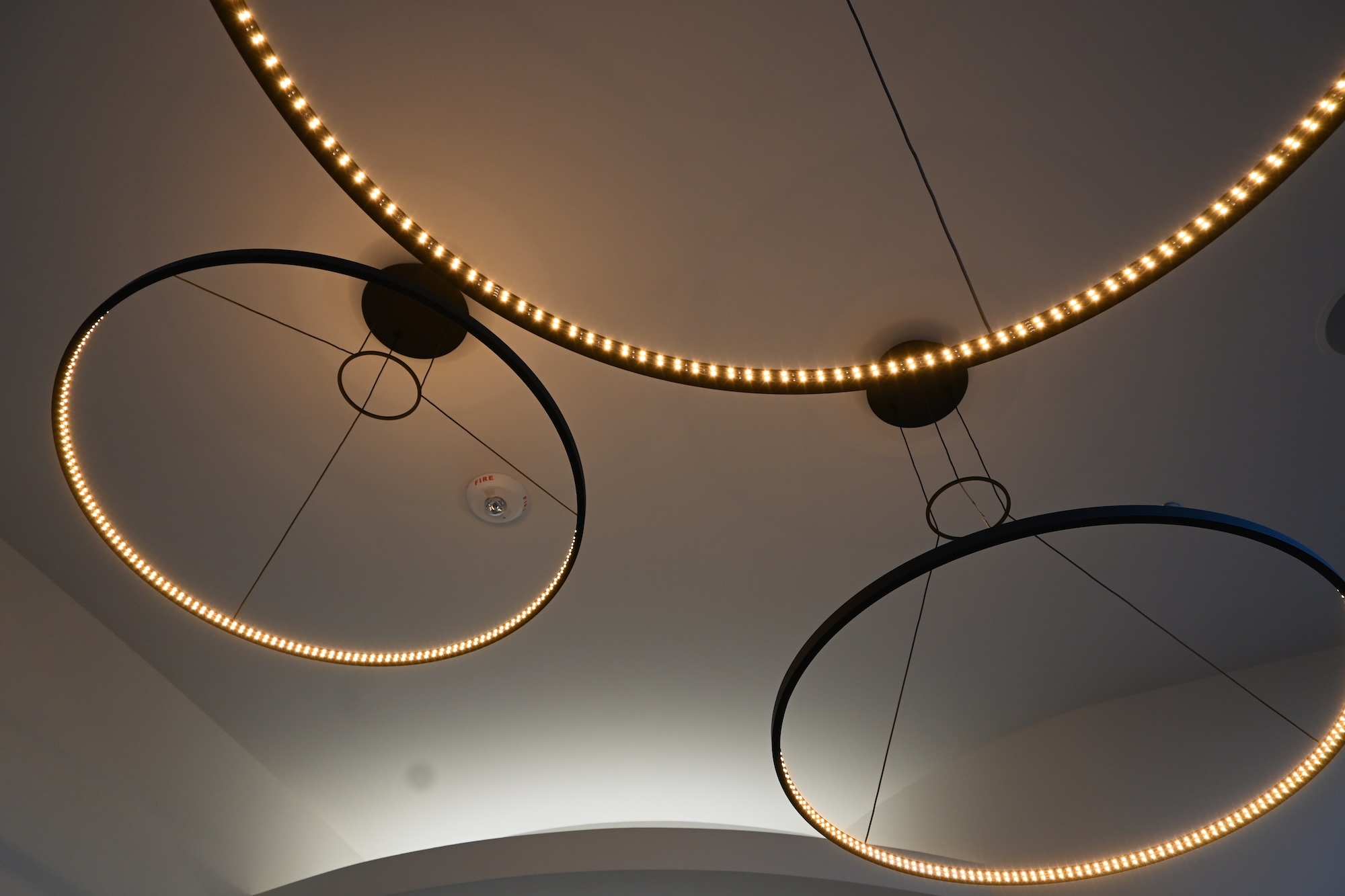 Modern lighting fixtures with circular designs in a Roseville, CA interior, featuring warm LED accents.