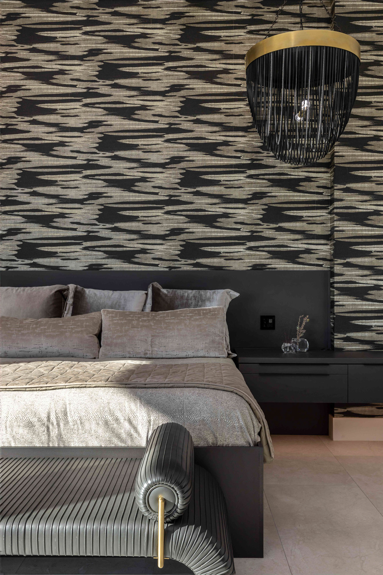 Luxury bedroom in Lincoln, CA featuring a patterned dark wall, elegant chandelier, and plush bedding.