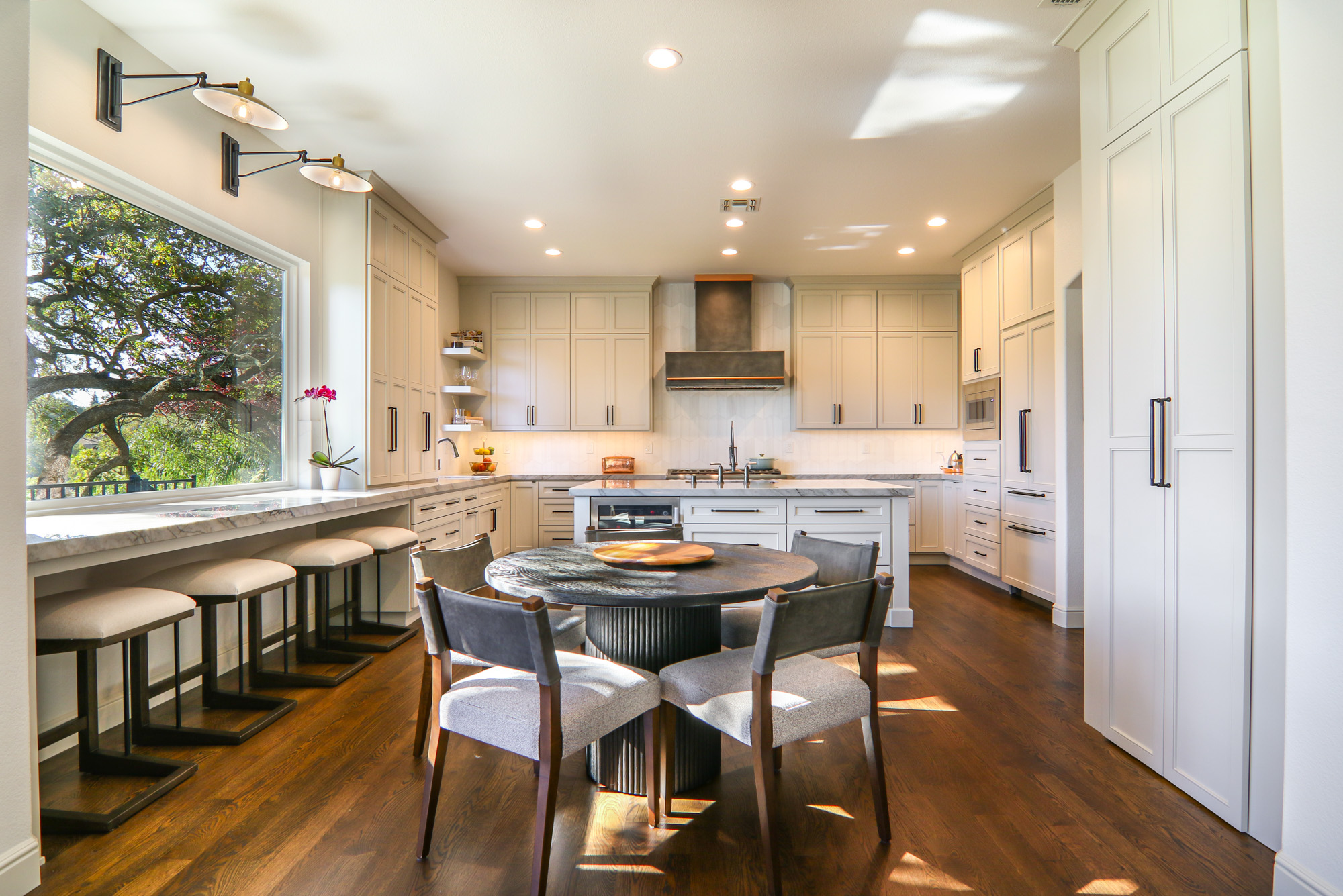 Modern kitchen design featuring light cabinetry, marble countertops, and elegant seating in Roseville, CA.