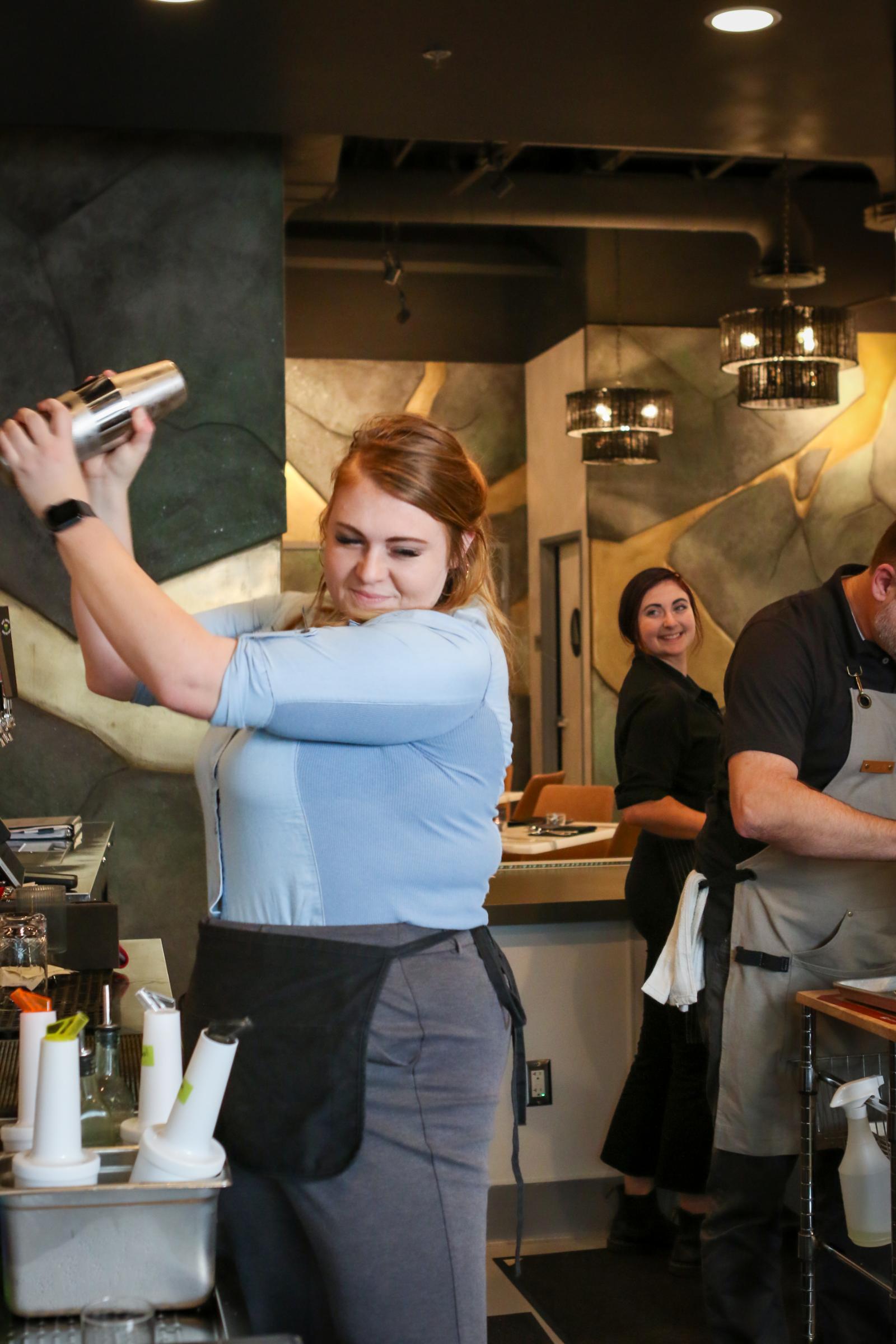 A bartender making cocktails in a modern bar with stylish decor in Lincoln, CA.