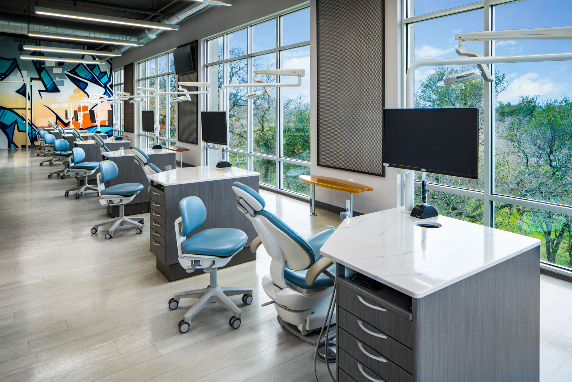 Open-concept dental office in Roseville, CA featuring modern design, large windows, and ergonomic chairs.