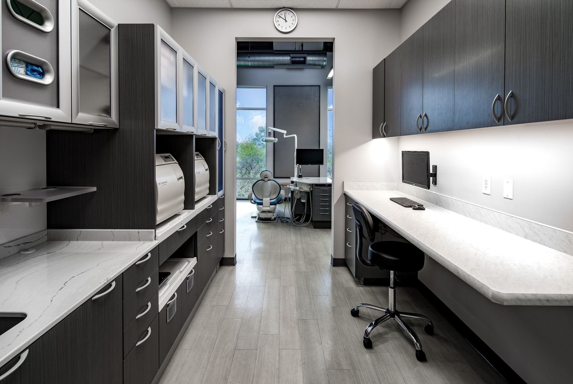 Modern dental office workspace featuring sleek cabinetry, marble countertops, and a clinical examination area in roseville, ca.