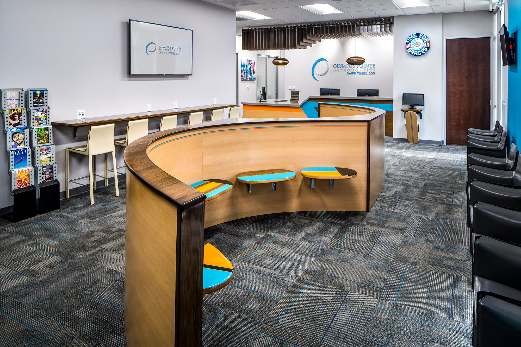 Contemporary dental office reception area in Roseville, CA, featuring curved seating, wooden accents, and vibrant colors.