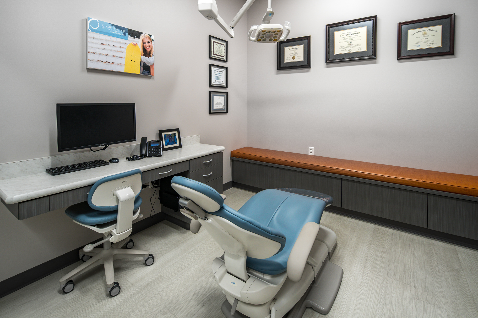 Modern dental office private room in Roseville, CA featuring blue dental chair and gray cabinetry.