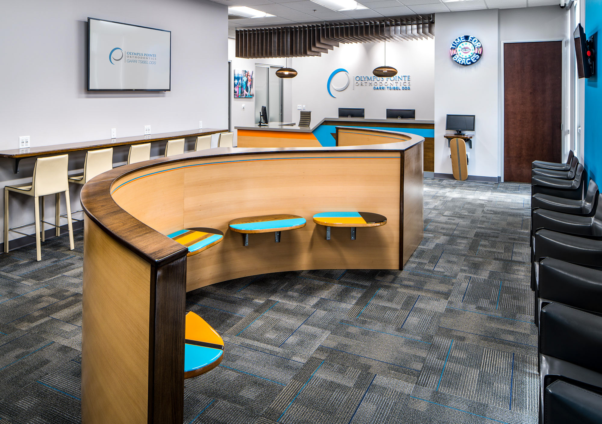 Modern dental office interior in Roseville, CA featuring a curved reception desk, vibrant seating, and sleek decor.