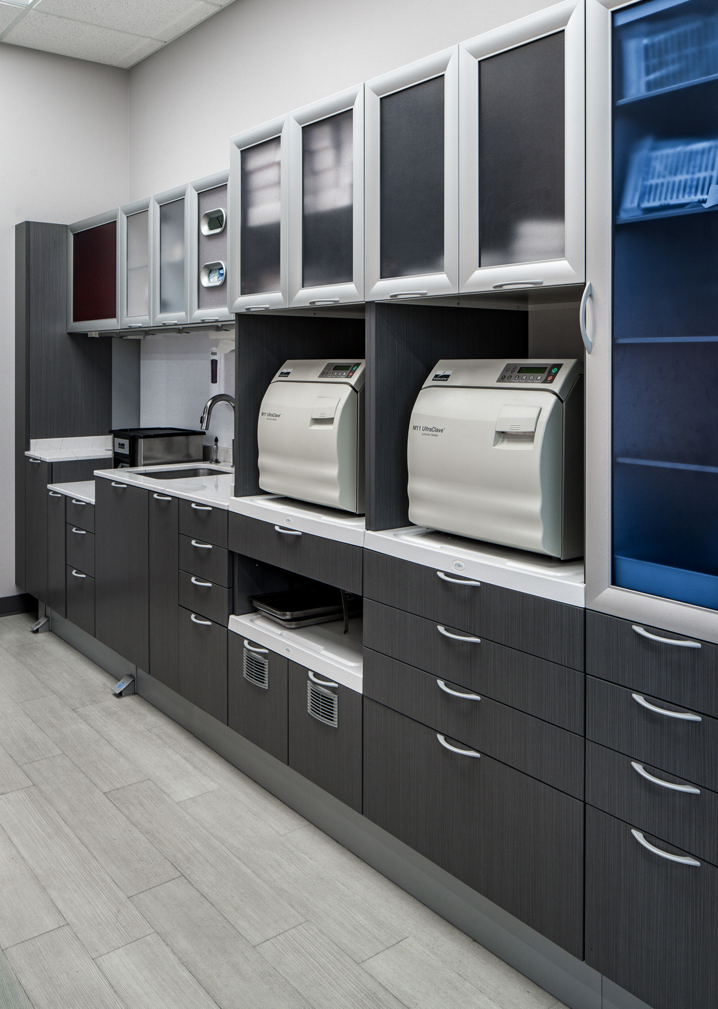 Modern dental office workspace with gray cabinetry and sterilization equipment in Roseville, CA