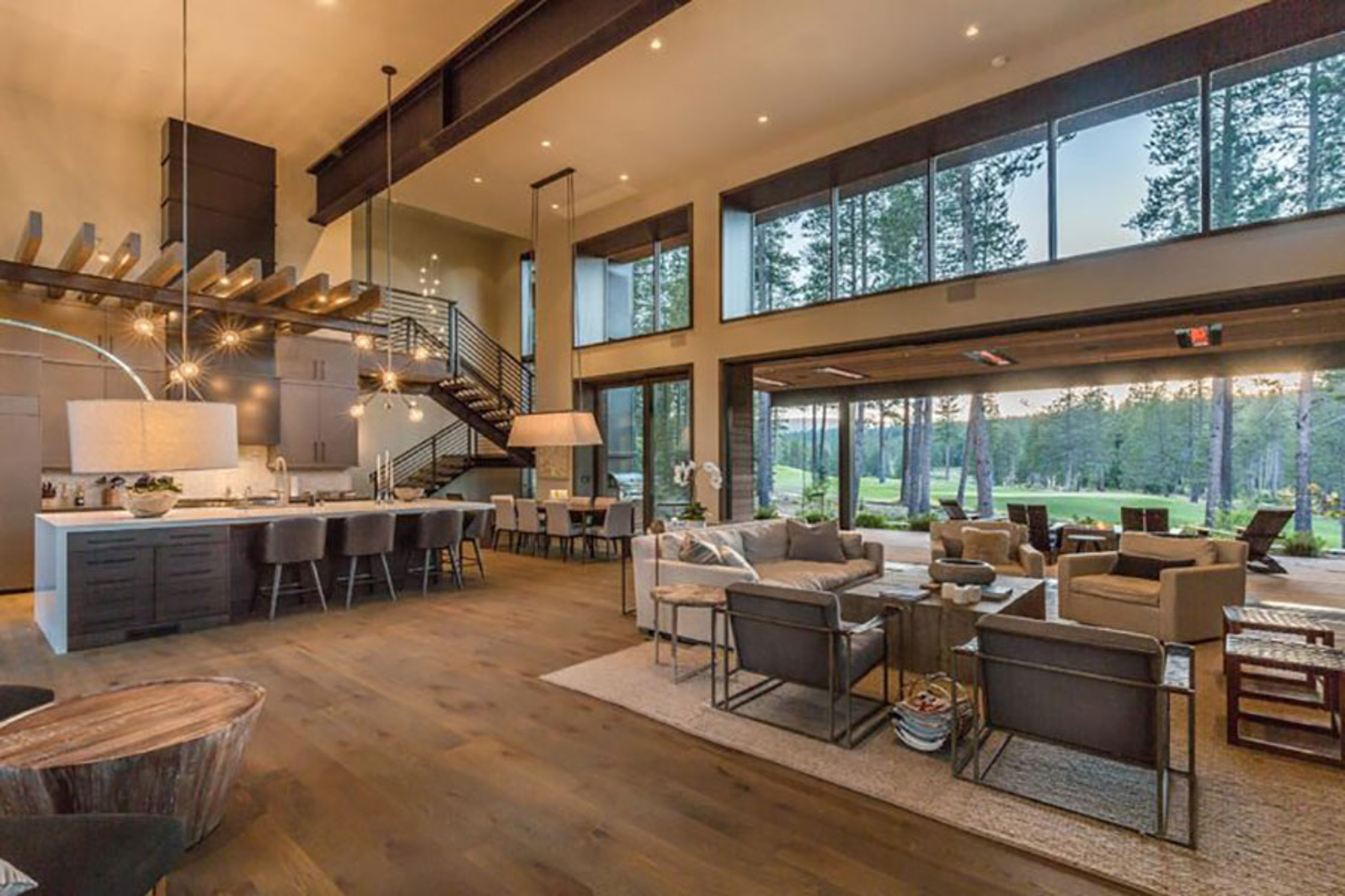 Modern living room with large windows showcasing views of Martis Camp, Truckee, CA, featuring contemporary furniture and stylish decor.