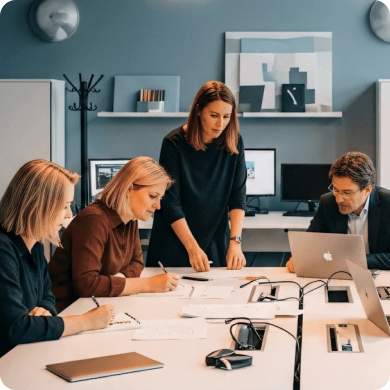 Diverse fundraising team collaborating on capital campaign launch strategy in conference room