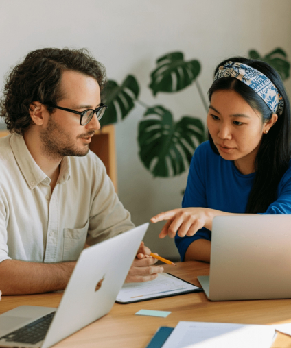 Nonprofit consultants collaborating on capital campaign strategy with laptops and documents