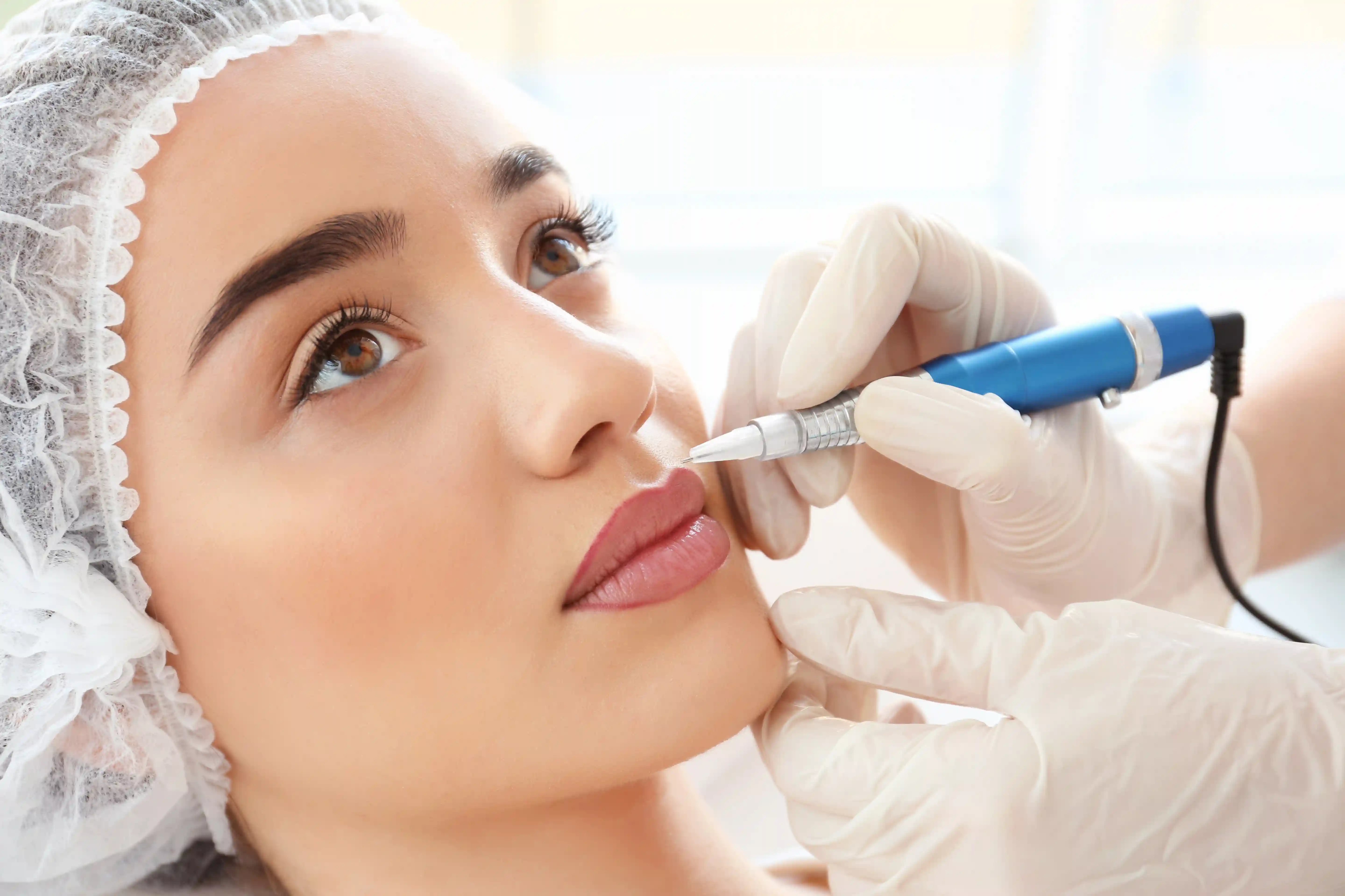 A beautiful woman getting her lips tattooed at a spa.