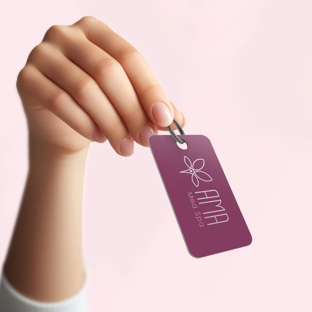 A hand holding up an AMA Membership keytag. The key tag has the AMA Logo on it.