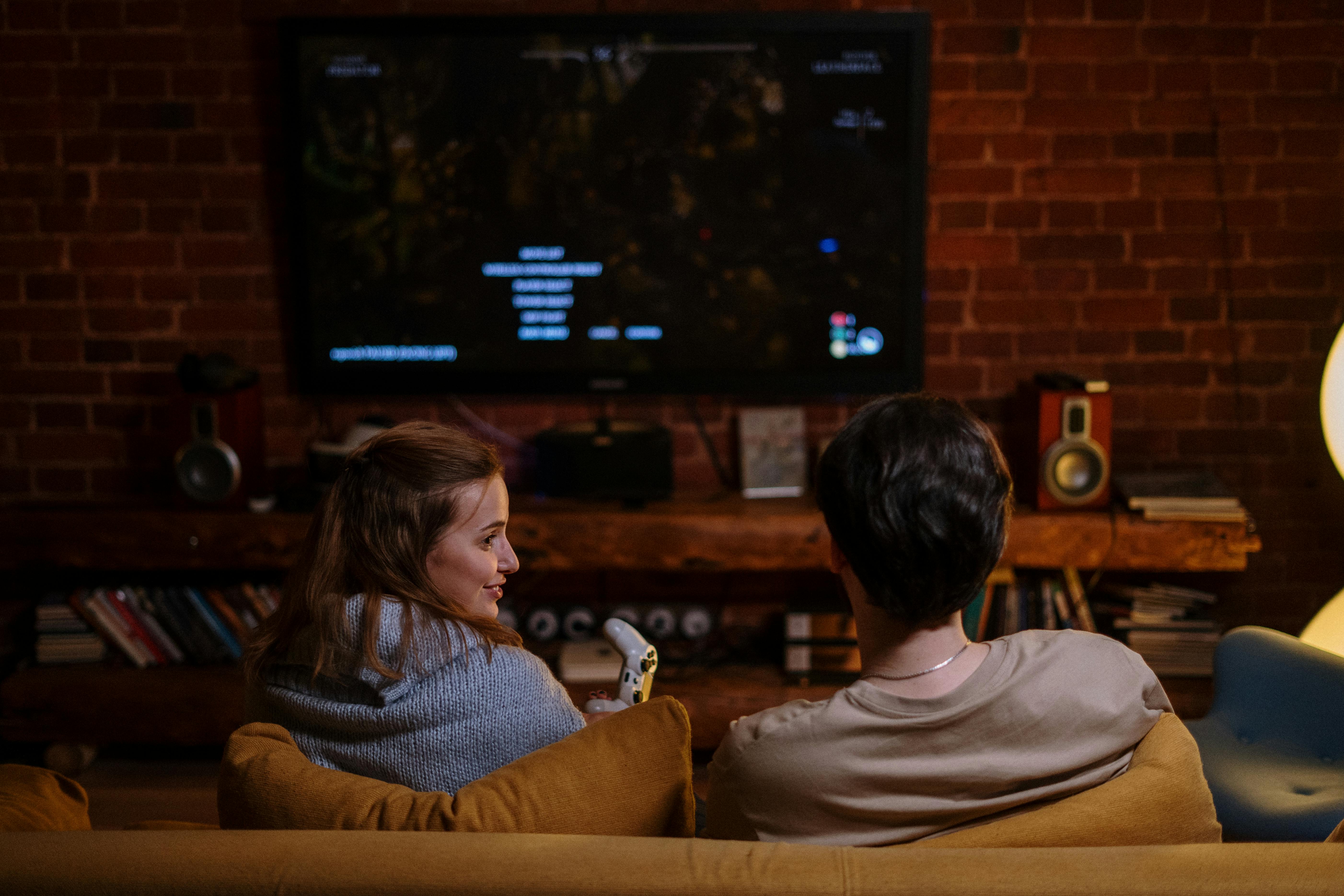 Photo of a couple playing games on a couch