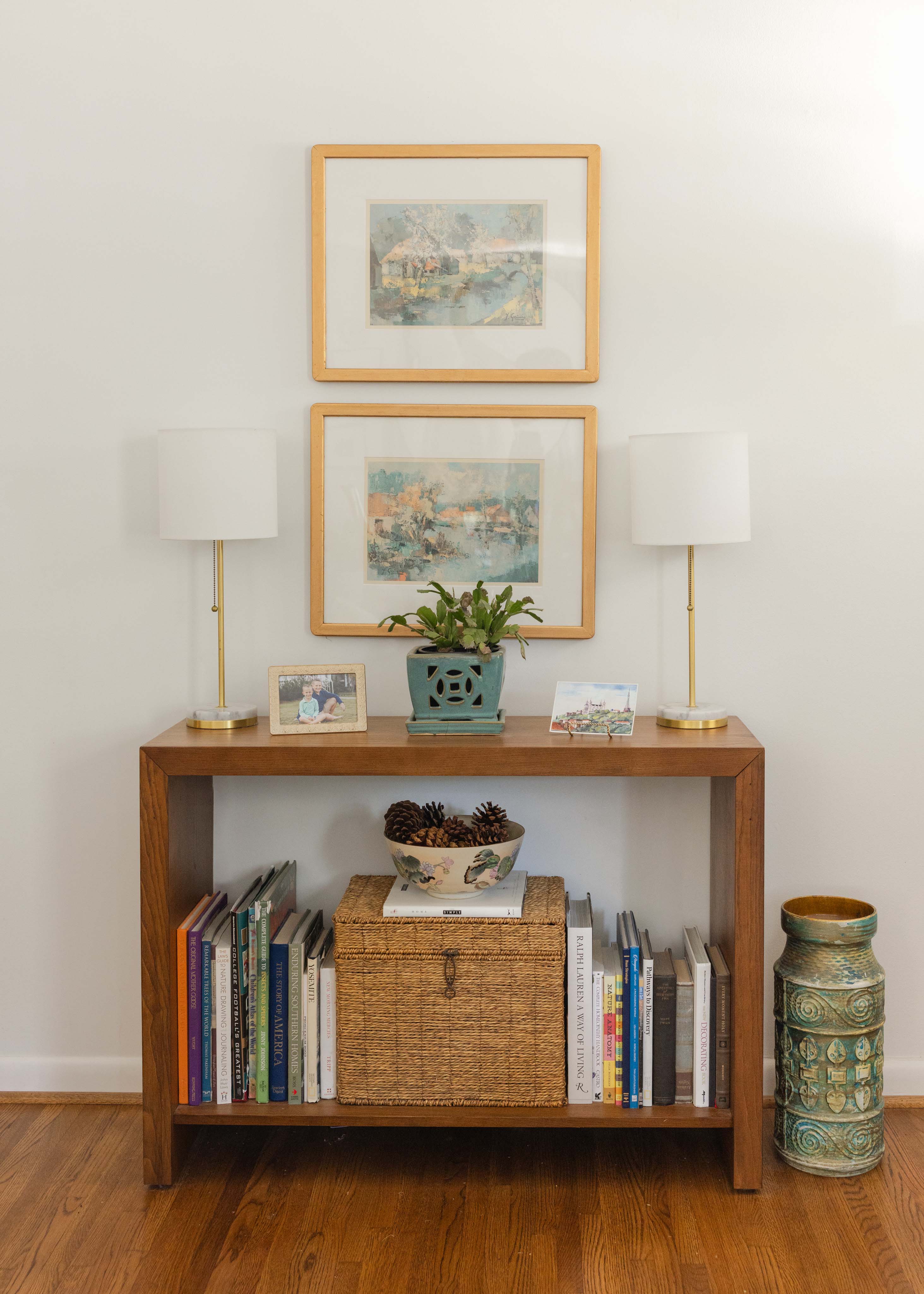 Modern kitchen with light blue cabinets, stainless steel oven and dishwasher, floral wallpaper, and a window above the sink.