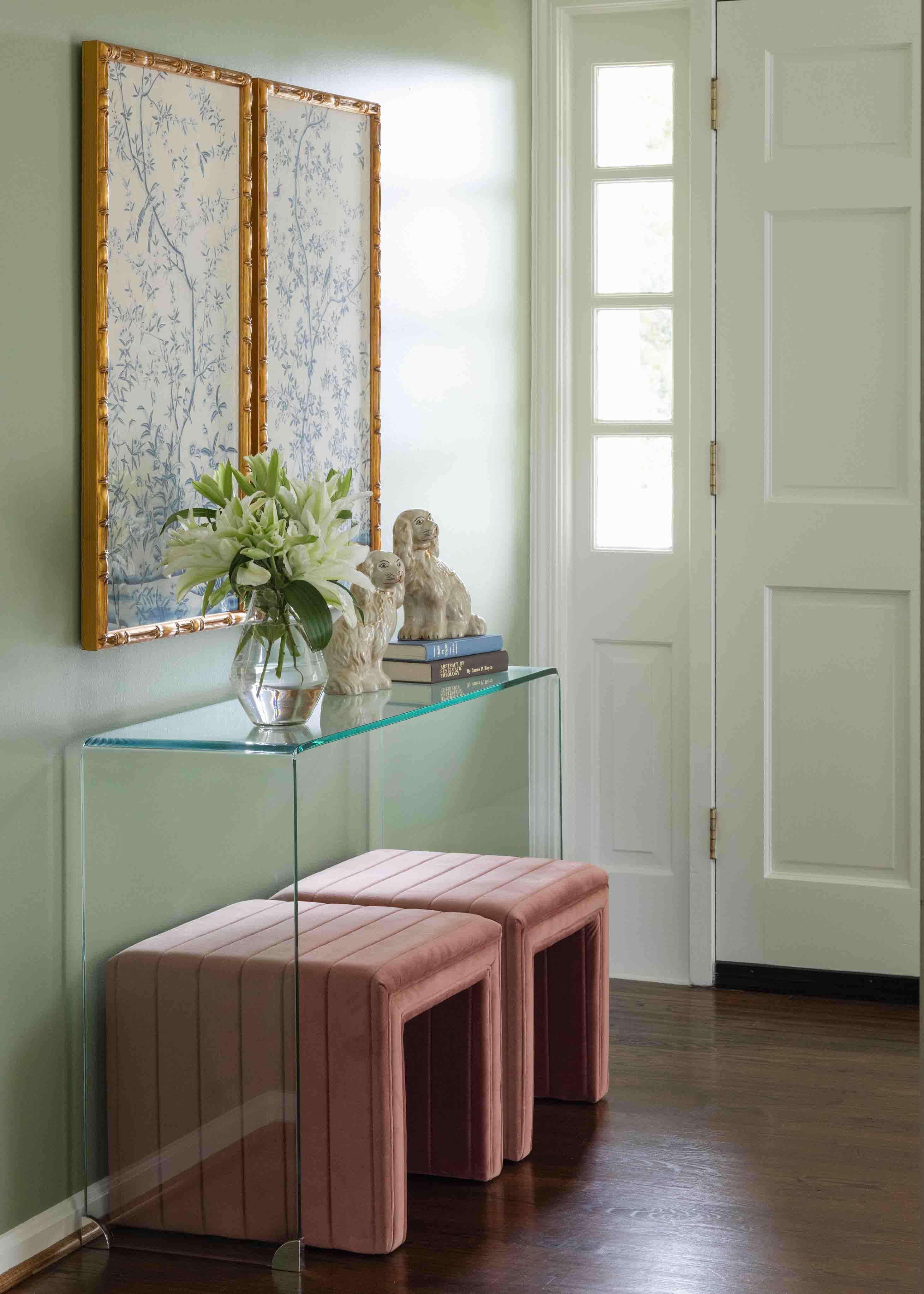 Entry way with a glass table and two pink stools