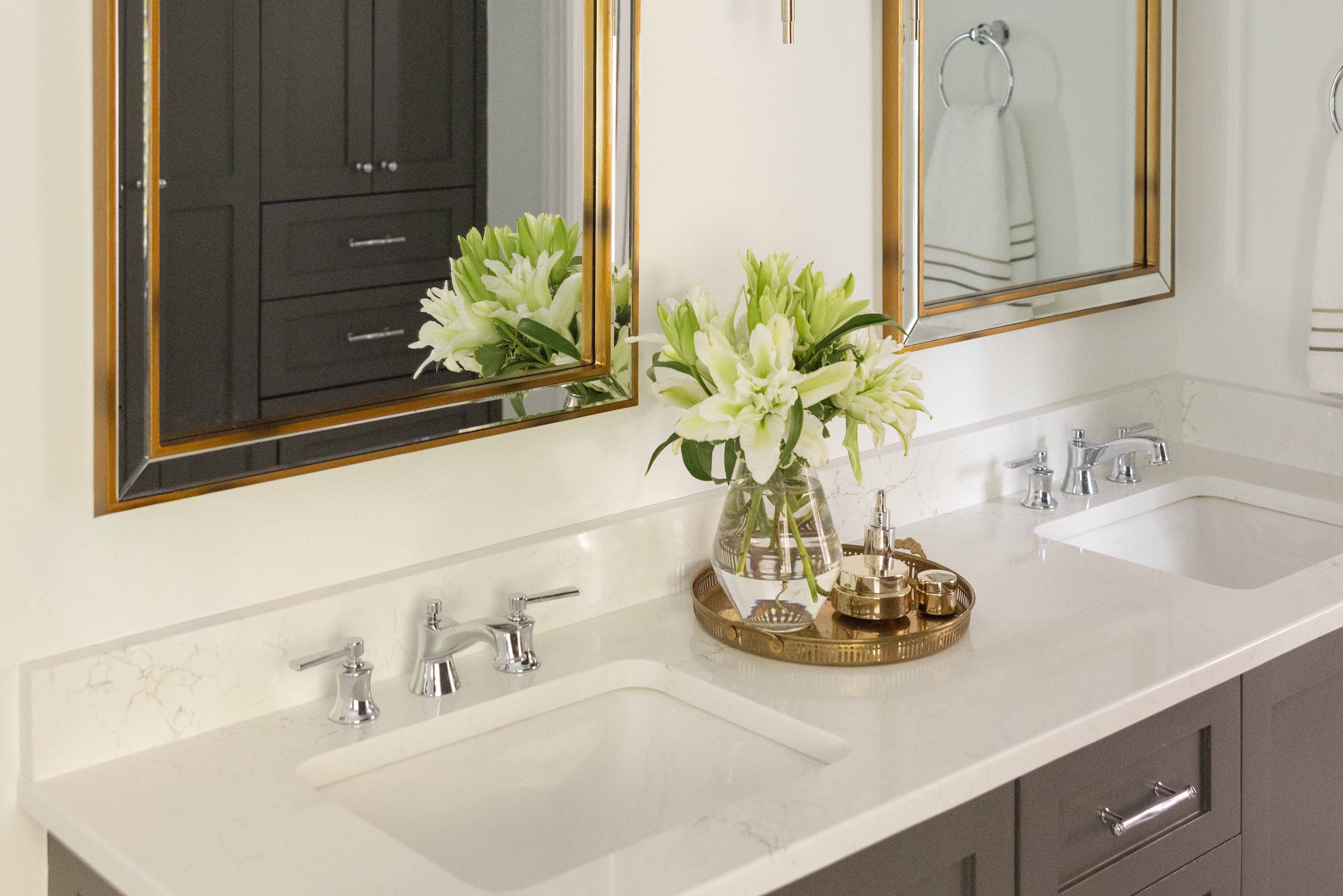 Bathroom Counterop with Gold Mirrors and Vase with flowers on a gold tray