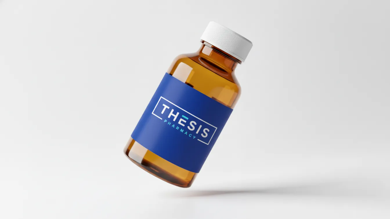 Brown medicine bottle with white cap and blue label reading Thesis Pharmacy floating on white background.