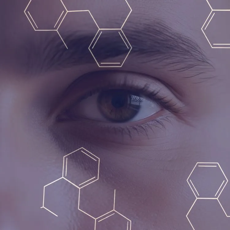 Close-up of a human eye with brown iris and eyebrow, overlaid with hexagonal chemical structures.