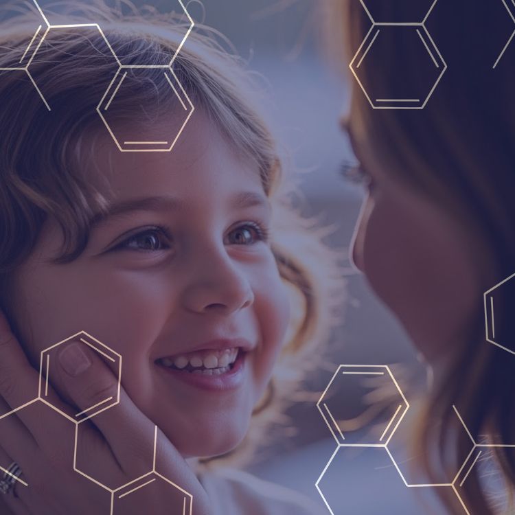 Smiling young child looking at an adult who tenderly holds the child's face, with transparent hexagonal patterns overlay.