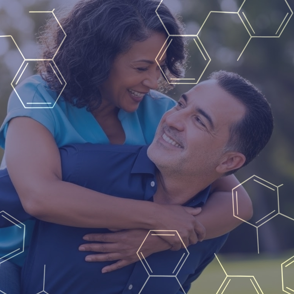 Smiling middle-aged couple embracing outdoors with abstract hexagonal molecular shapes overlay.