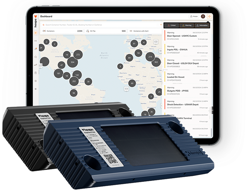 Two portable tracking devices in front of a tablet displaying a global shipping container tracking dashboard with map and alert notifications.