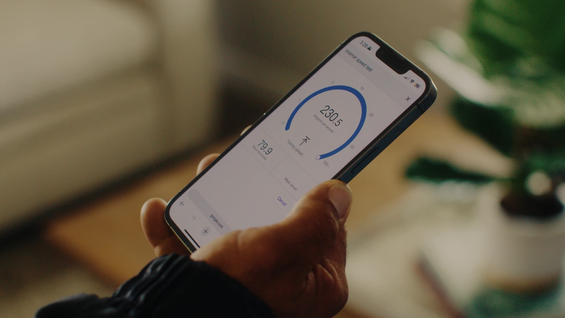Person holding smartphone showing internet speed test with 230.5 Mbps download and 79.9 Mbps upload.