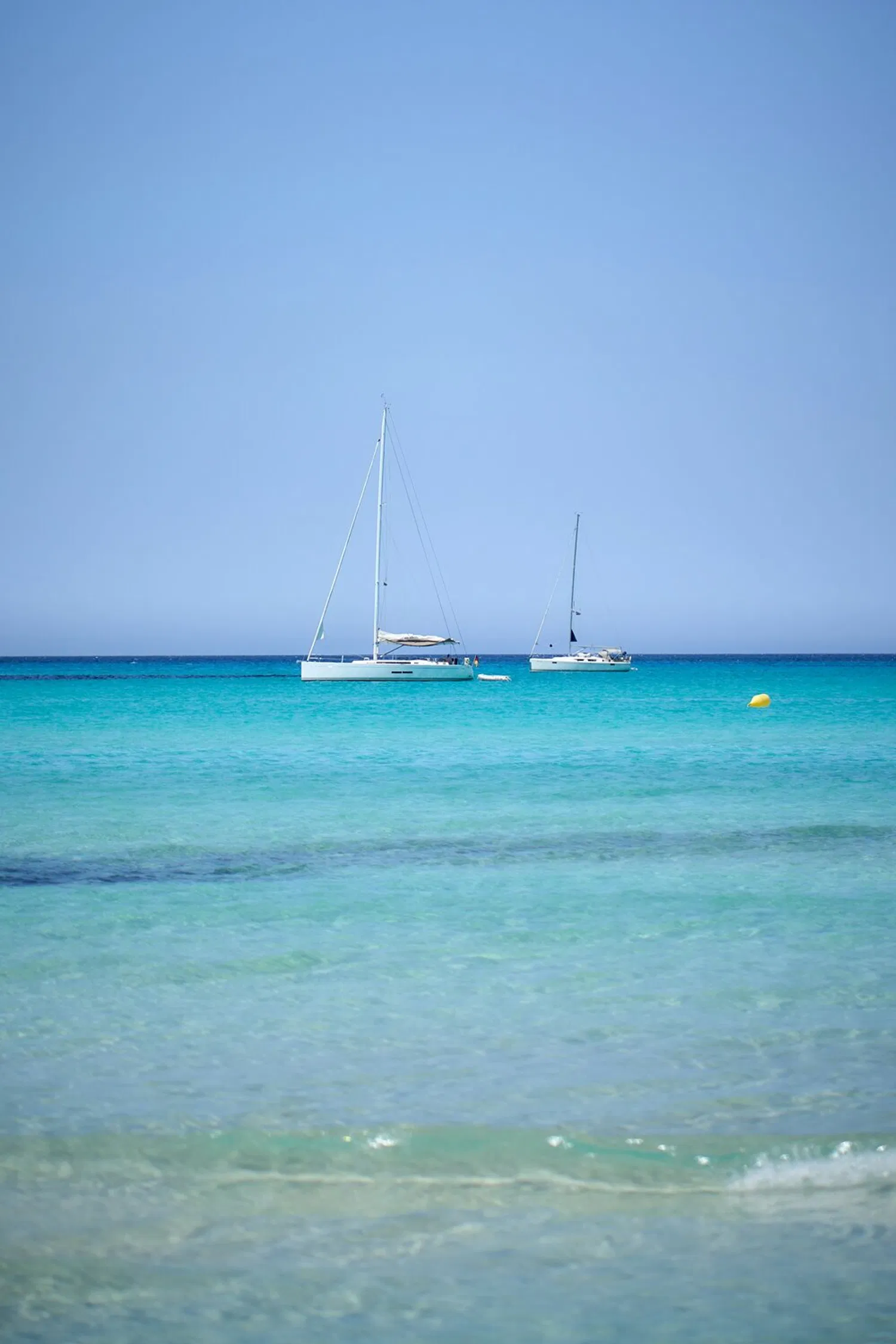 A luxury yacht anchored in the turquoise waters of a secluded Mallorcan cove.
