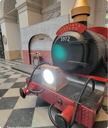 Réplique de l'avant de la locomotive à vapeur Poudlard Express sur un sol en damier.