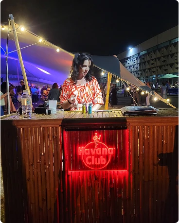 Une personne mixant de la musique sur un stand de DJ en bambou lors d'un événement nocturne.