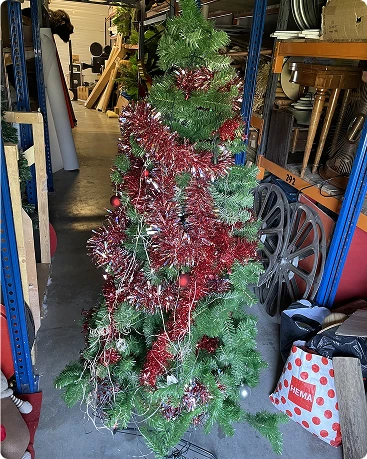 Longue guirlande de Noël floquée de neige artificielle et décorée de baies rouges, en stockage.