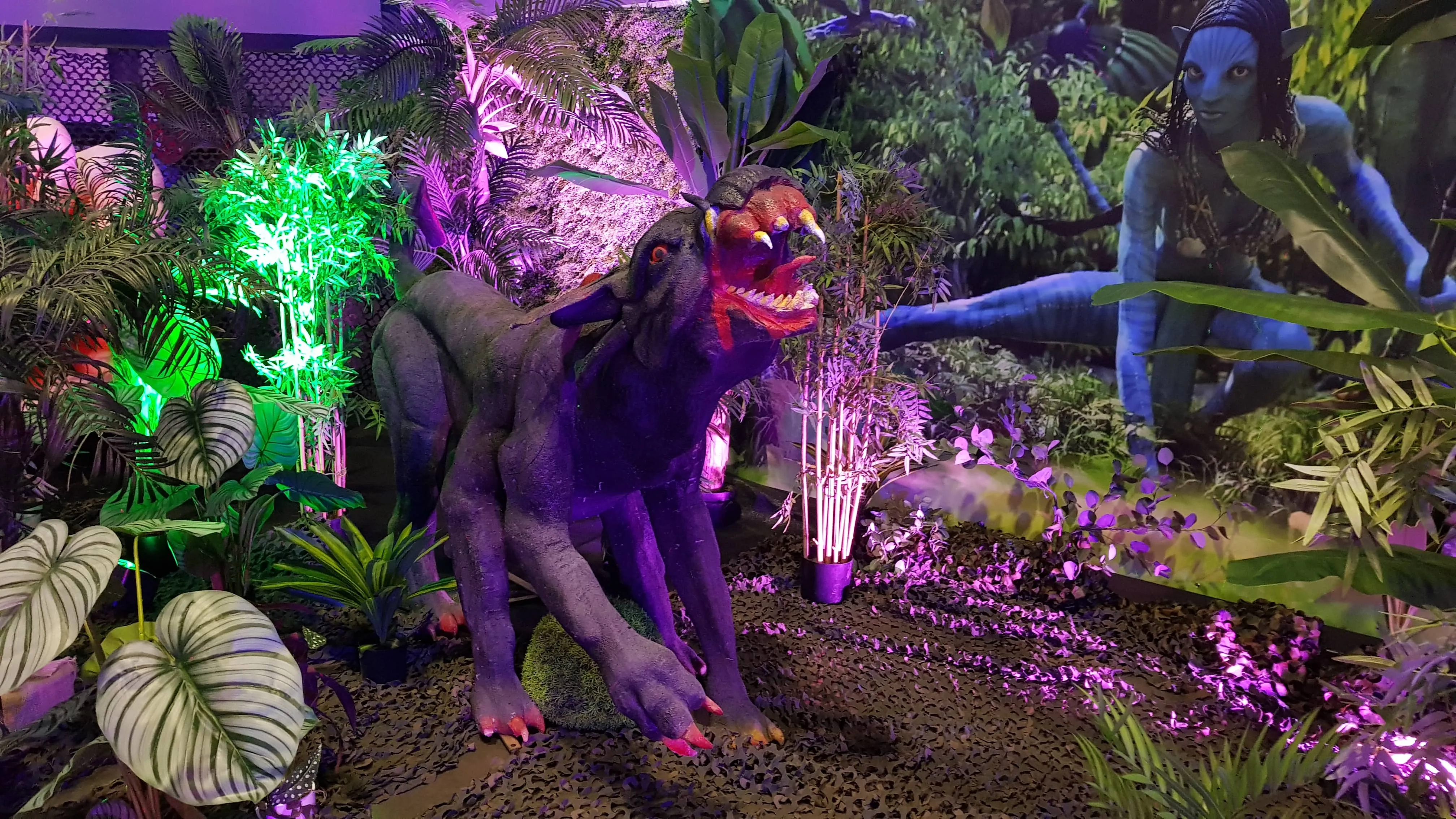Statue d'une créature féline noire de Pandora dans un décor de jungle bioluminescente.