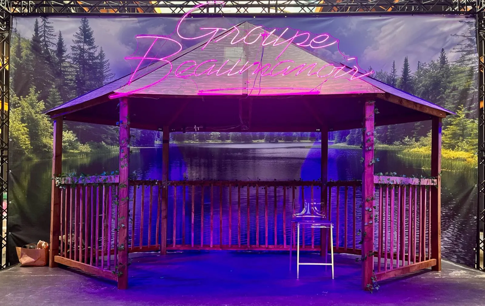 Un kiosque ou pavillon en bois vide, éclairé par une lumière bleue dans un décor nocturne.