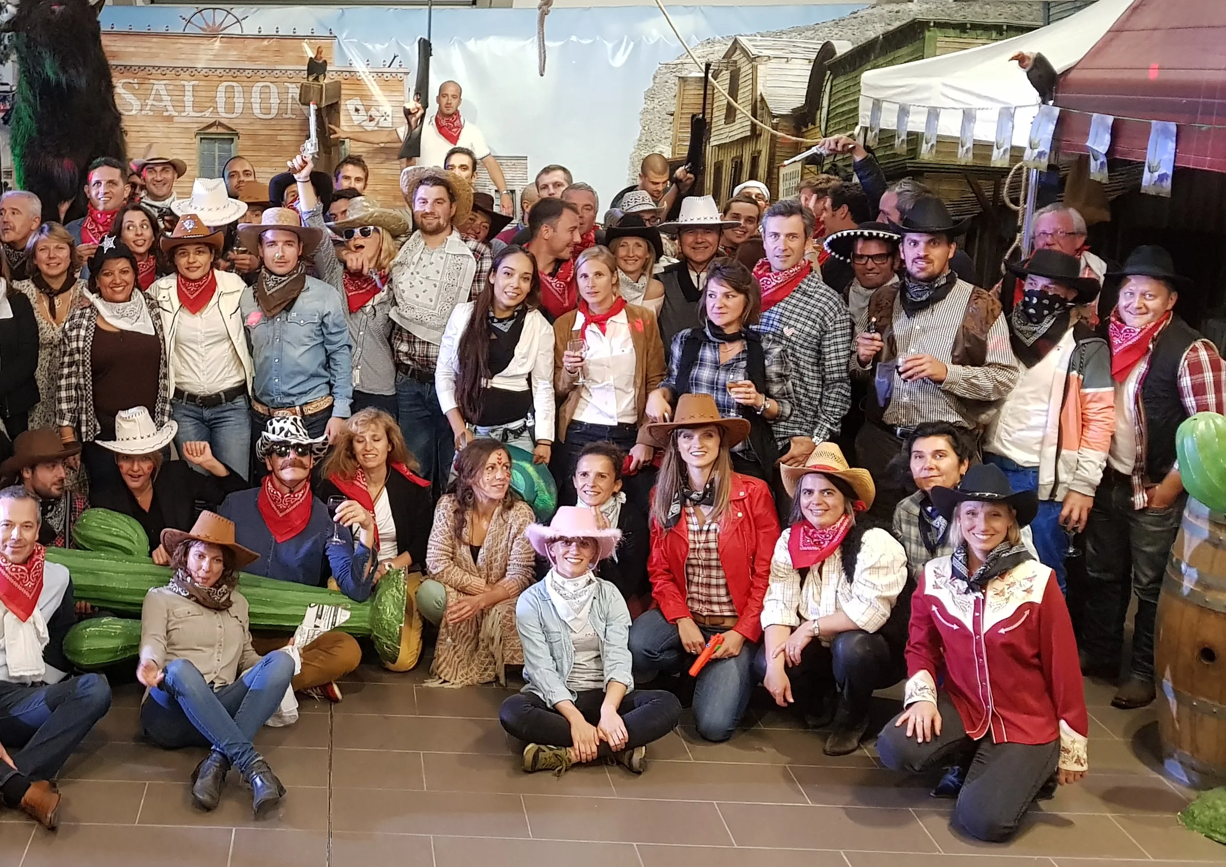 Une grande photo de groupe de personnes portant des foulards rouges et des tenues sur le thème du western.