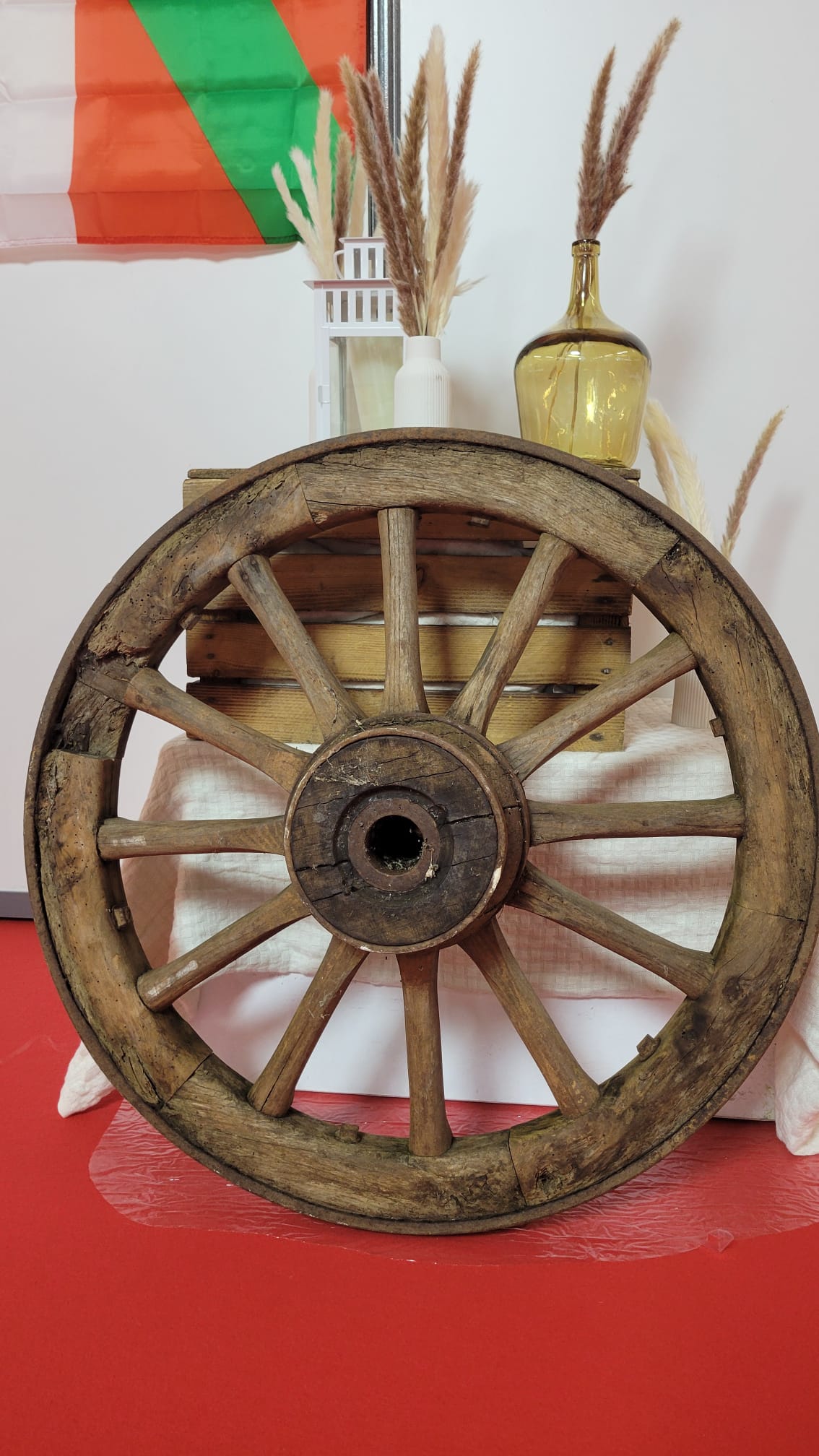 Roue de charrette ancienne en bois utilisée comme élément de décoration pour scénographie rustique, champêtre ou western