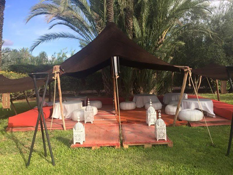Tente berbère événementielle aménagée en espace lounge avec poufs et lanternes, idéale pour une soirée à thème oriental ou un événement professionnel en extérieur.