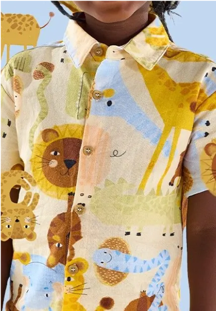 Child wearing a button-up shirt with colorful animal prints including lions, giraffes, and snakes on a light background.