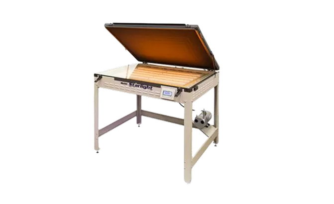 Industrial kiln with an open orange-tinted lid on a metal frame for firing ceramics or glass.