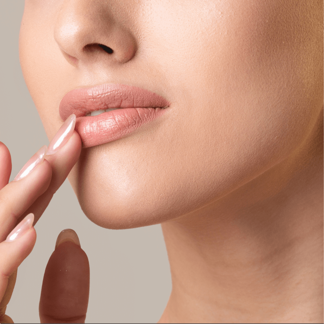 A woman putting on lipstick with her fingers.