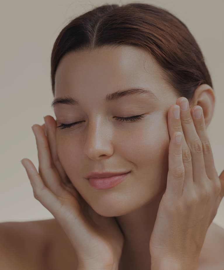 A woman holding her hands to her face.