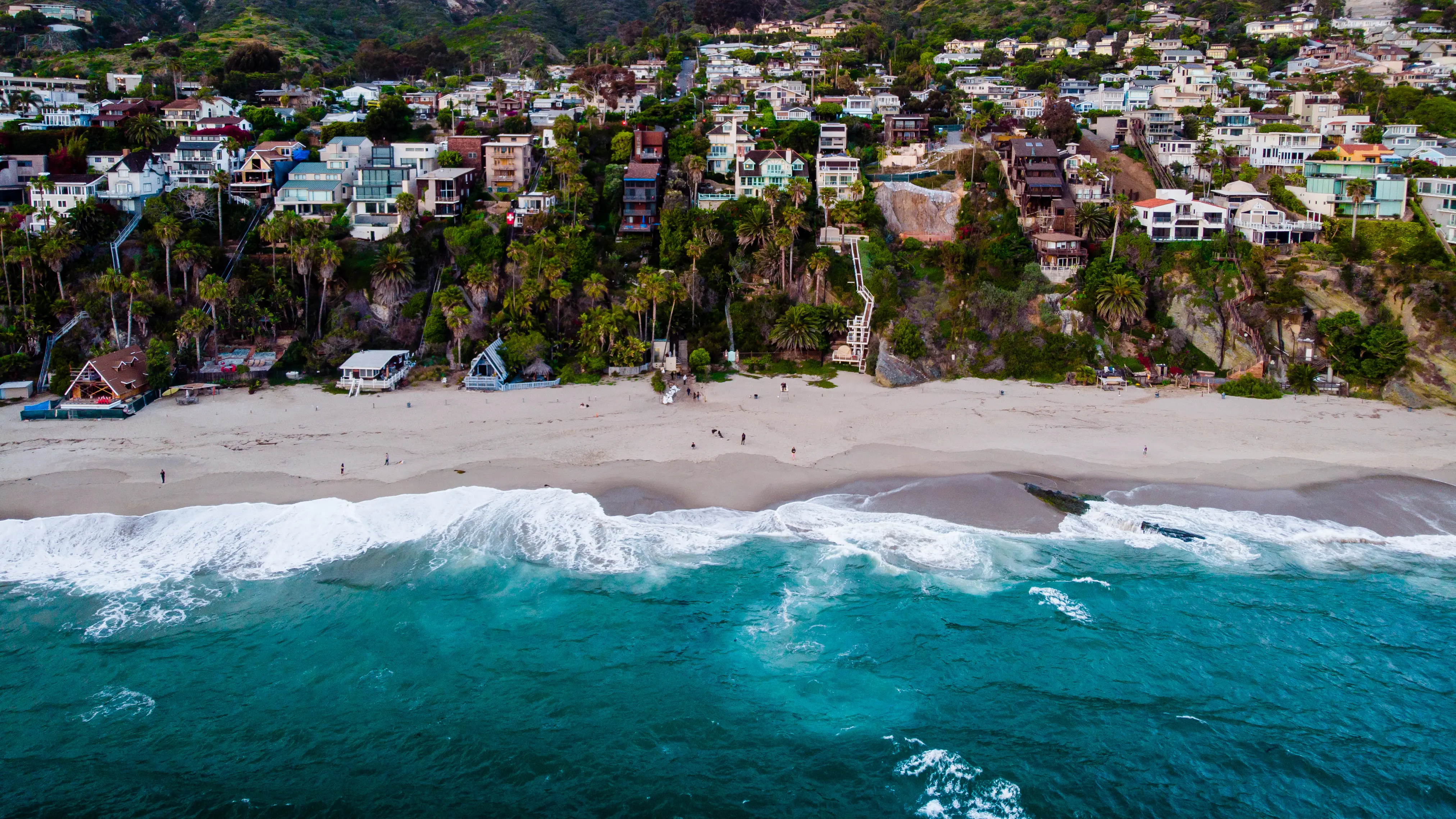 An aerial view of a beach with houses on it.