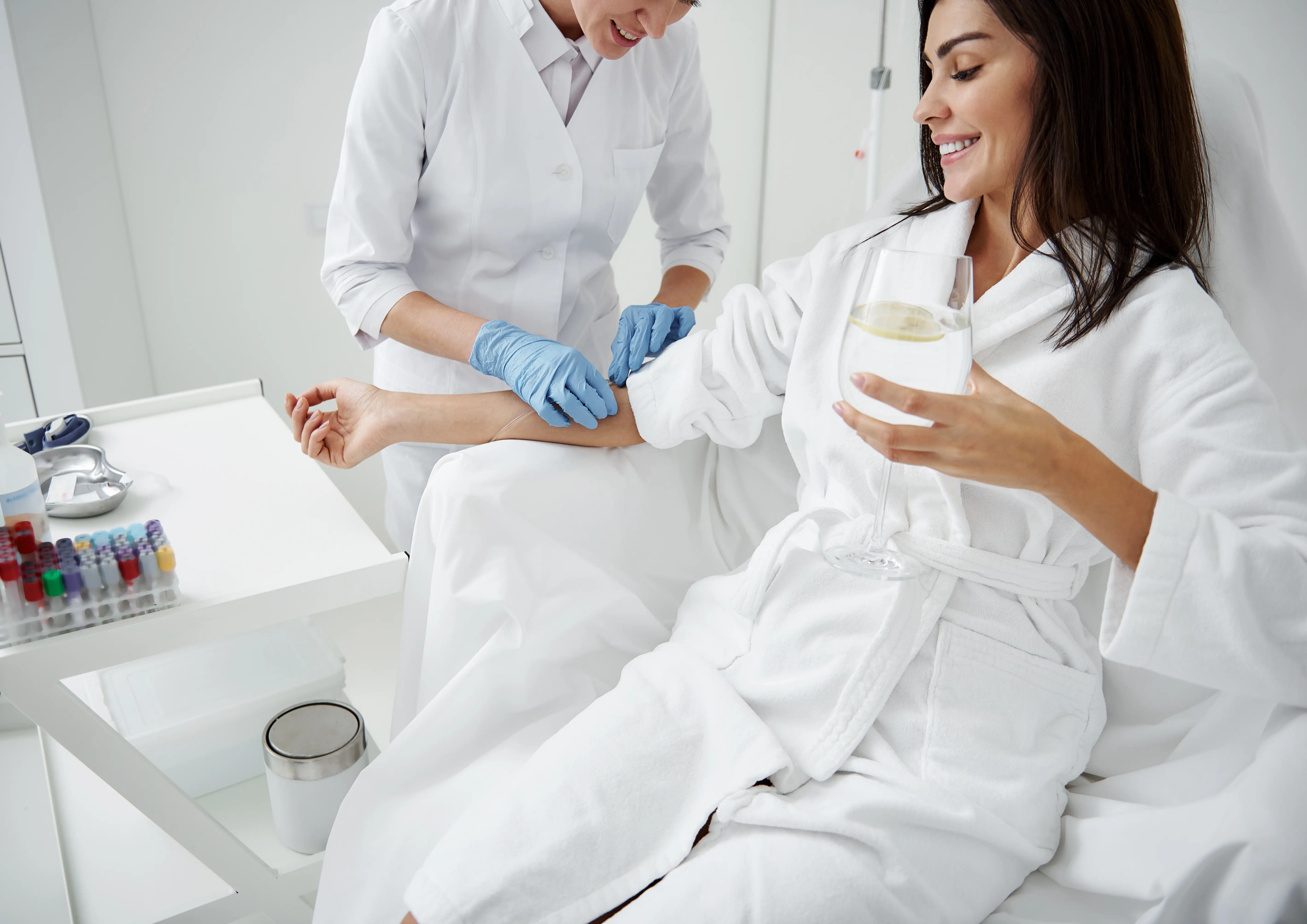A woman in a white robe getting her nails done.