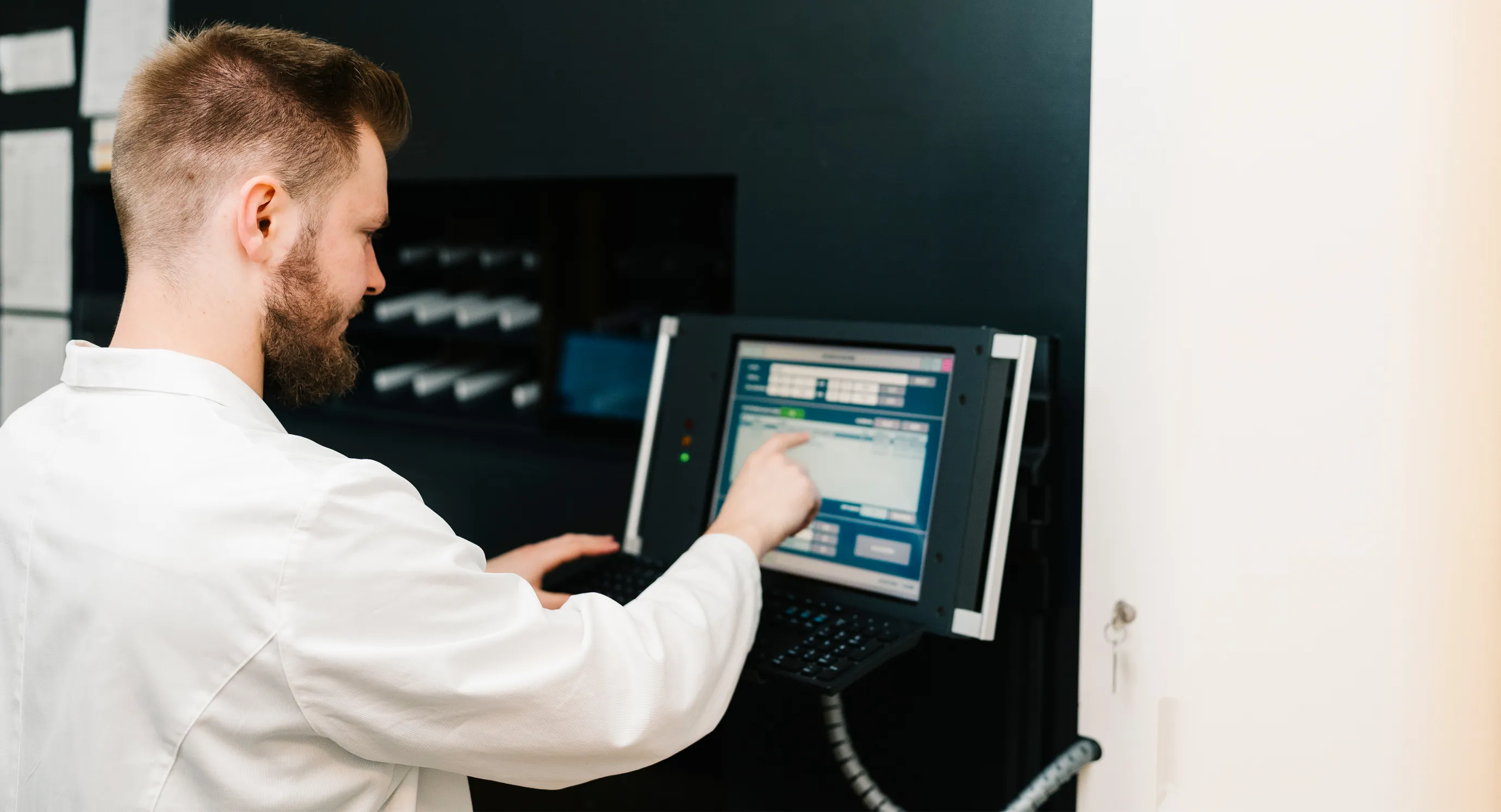 Mitarbeiter der Grapengießer Apotheke bedient den Kommissionierroboter über ein Touch-Display – Symbol für moderne, DSGVO-konforme Datenverarbeitung und sicheren Umgang mit Kundendaten.