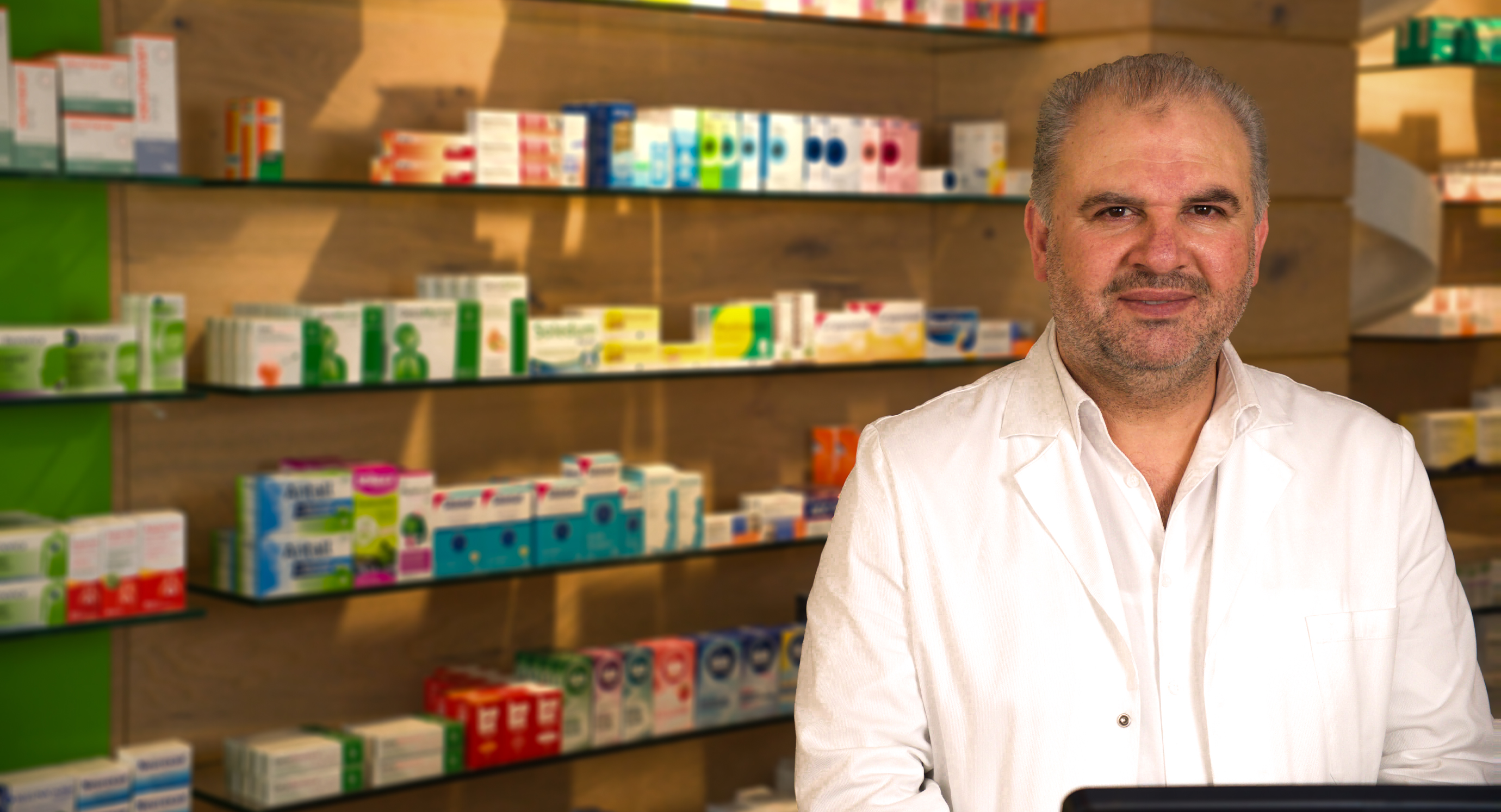 Kerstin Morawe, Pharmazeutisch-technische Assistentin bei der Grapengießer-Apotheke in Lüneburg, steht stellvertrendend für das gesamte Team lächelnd hinter dem HV-Tisch der modernen Apotheke. Im Hintergrund sind Regale mit Arzneimitteln und Gesundheitsprodukten zu sehen – ein Ort, an dem persönliche Beratung, pharmazeutische Kompetenz und digitale Services wie E-Rezept und Botendienst im Mittelpunkt stehen.