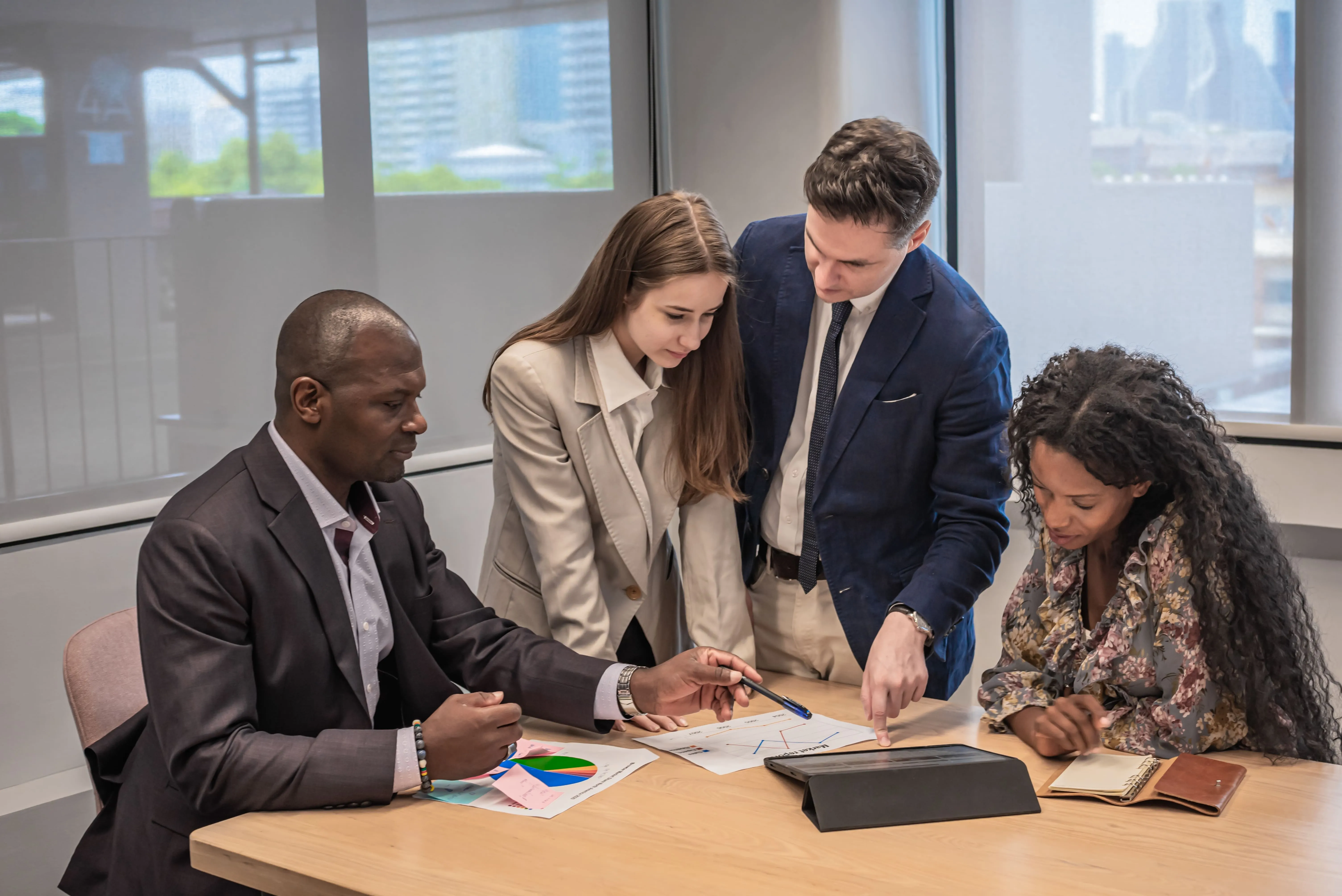 a group of workers looking at sheets of data