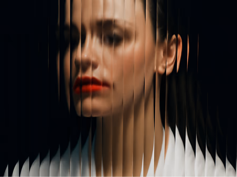 Blurred portrait of a woman with red lipstick seen through vertical textured glass.