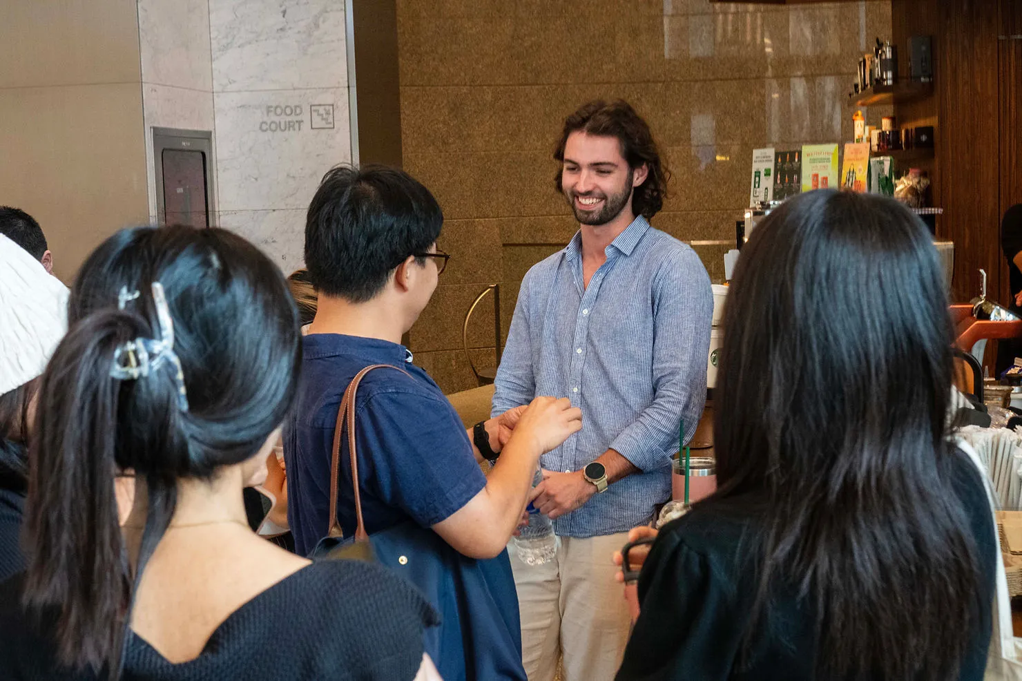 Thomas shares a warm farewell with his coworkers, creating a moment filled with smiles and camaraderie.