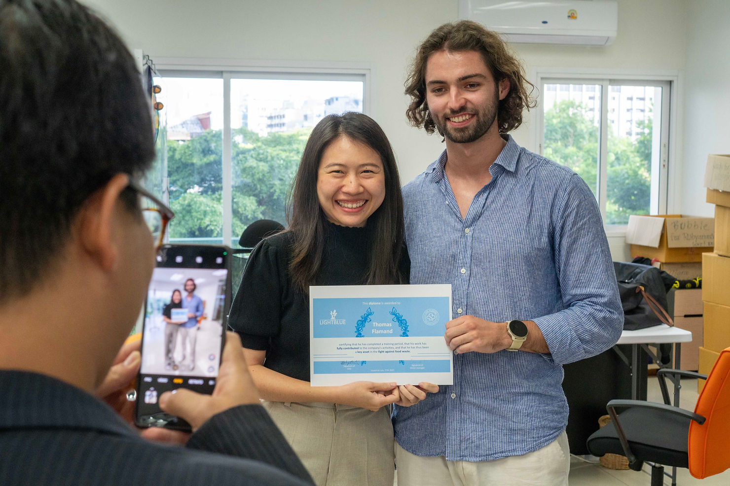 Thomas proudly holds a certificate recognizing his contributions to the FIT solution on his last day.